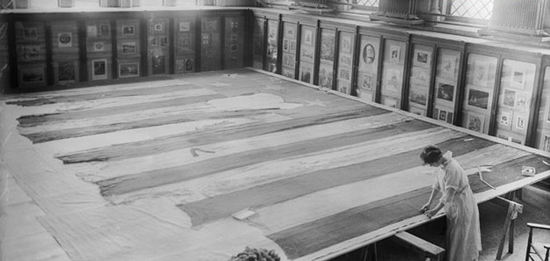A conservator works on the Star-Spangled Banner in 1914 